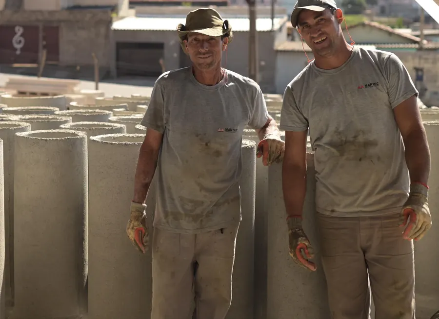Dois funcionários da Martec entre tubos de concreto na fábrica